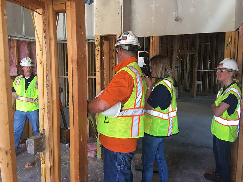 Construction workers check on an area of their project after flagging a problem on their construction photography