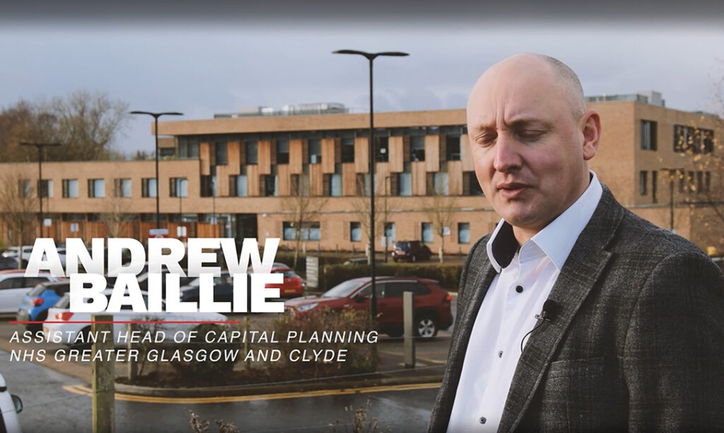 Andrew Baillie, Assistant Head of Capital Planning, speaks outside a modern NHS Greater Glasgow and Clyde building.