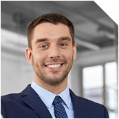 Professional headshot of a smiling man in a dark suit and blue tie.