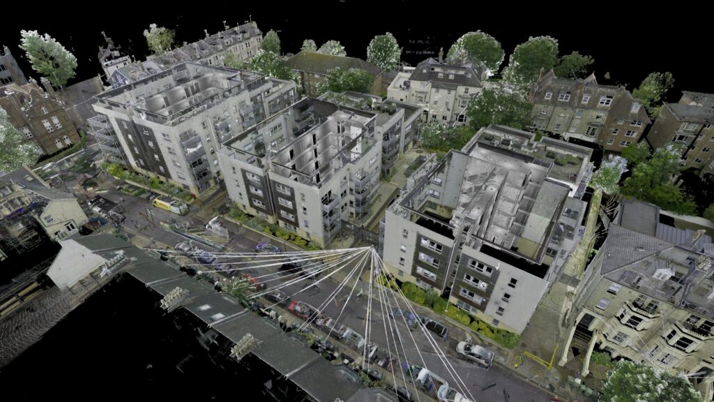 3D laser scan of an urban street with multi-story buildings, parked cars, and trees.