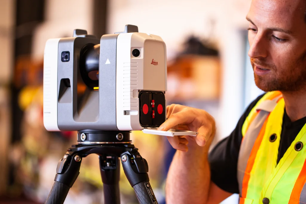 Engineer operating a Leica 3D laser scanner on a tripod.