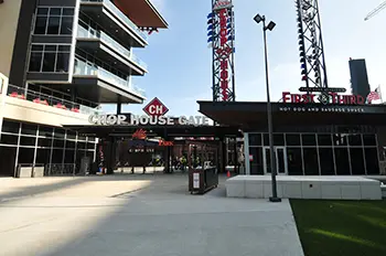 Daytime view of the Chop House Gate stadium entrance, featuring a First & Third hot dog shack.