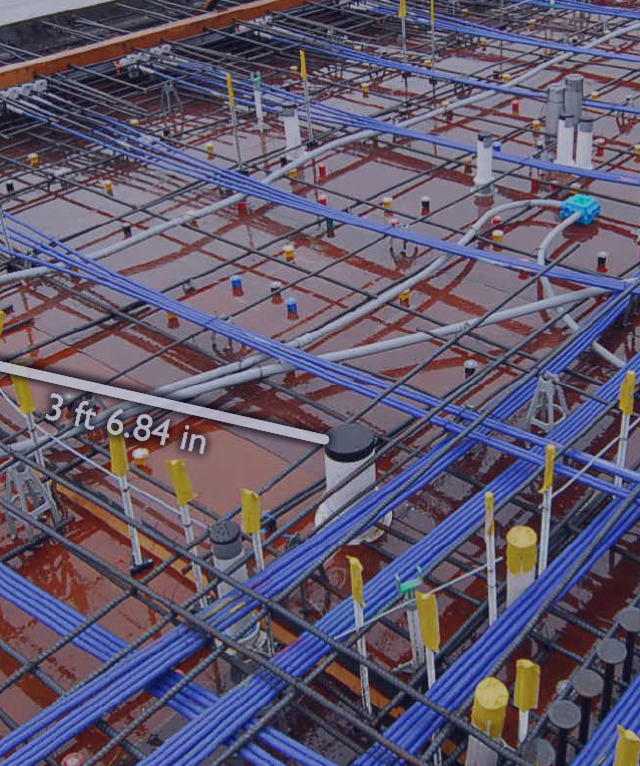 Construction site showing rebar grid, blue conduits, and various pipes with a 3 ft 6.84 in dimension.