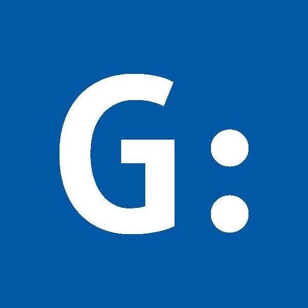 White uppercase letter G followed by a colon on a blue background.