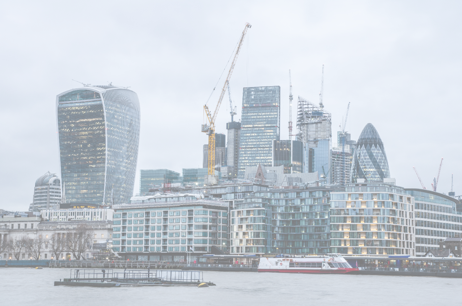 London financial district skyline on an overcast day, featuring the Walkie-Talkie, Gherkin, and River Thames.