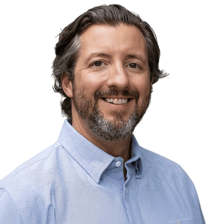 Smiling man with graying hair and beard wearing a light blue shirt.